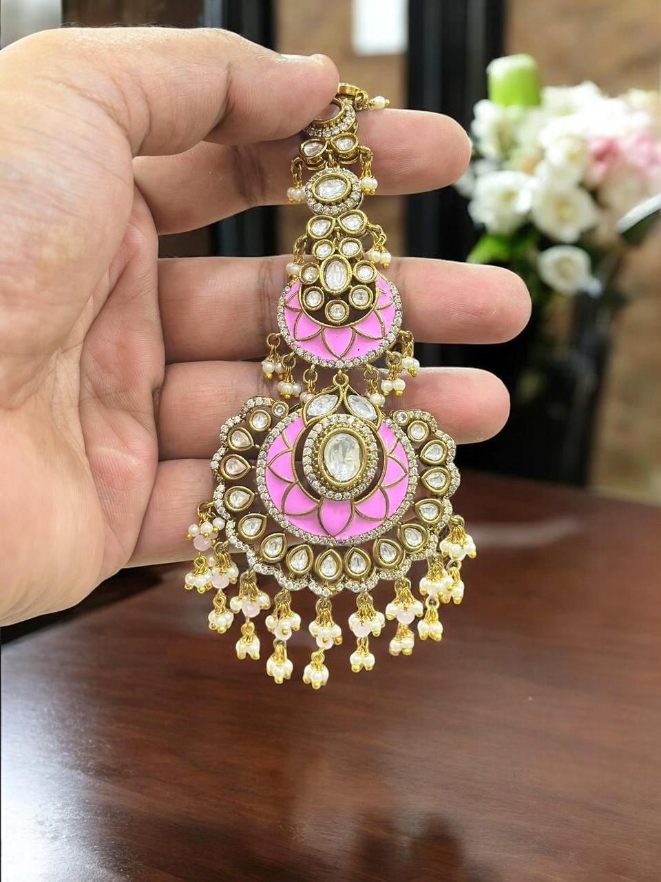 Graceful pink and gold-plated kundan maang tikka adorned with pearls, perfect for bridal and festive looks